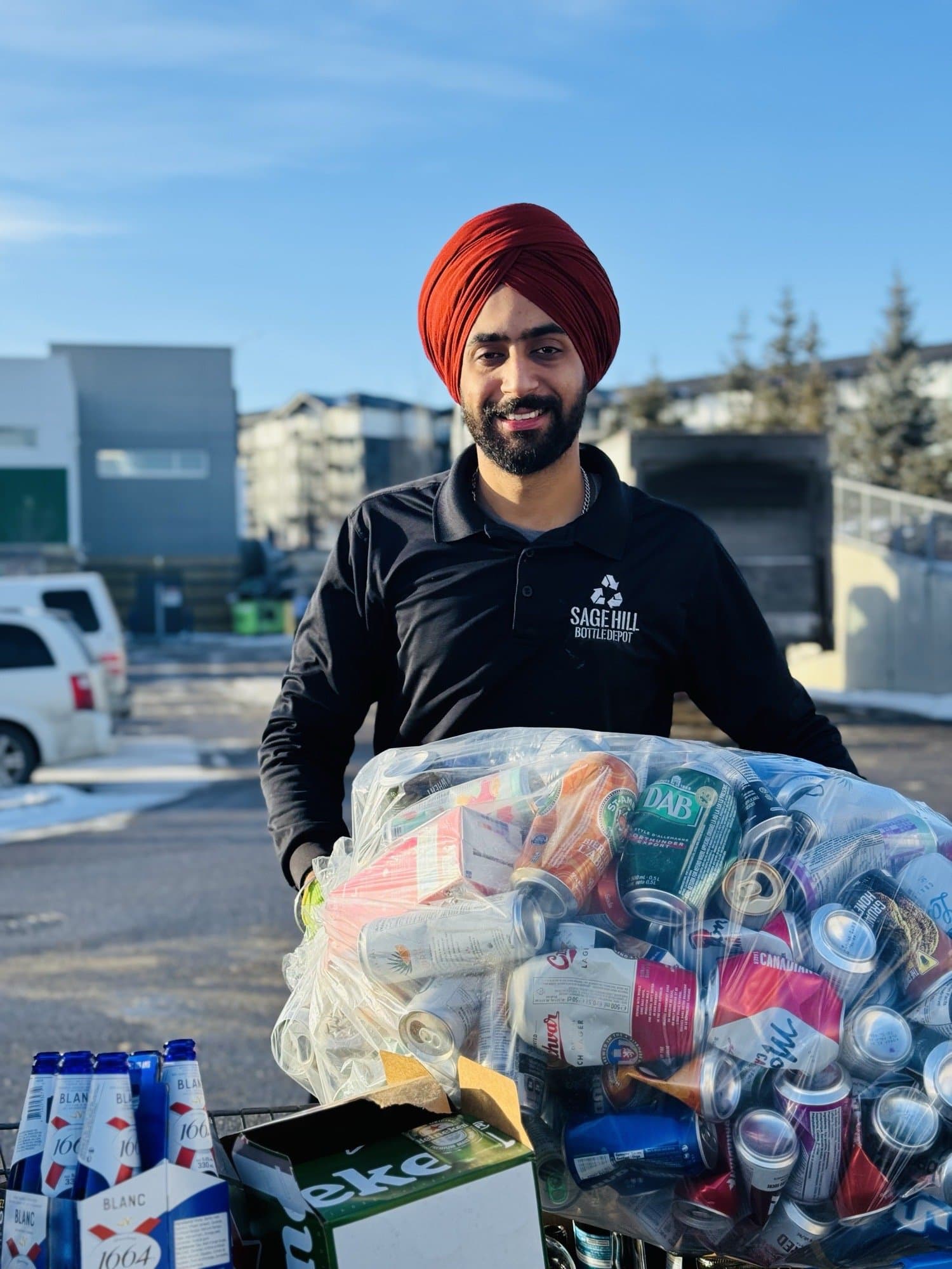 Sage Hill Bottle Depot staff carrying a full bag of containers during a valet drop-off